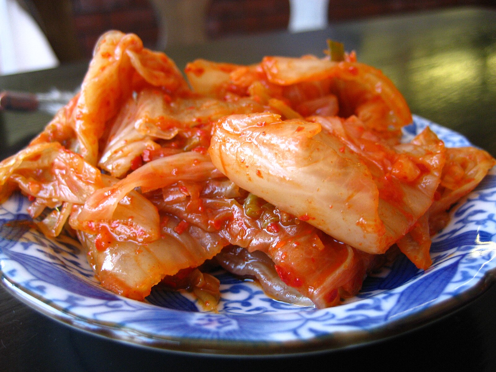 Kimchi on a blue and white plate.