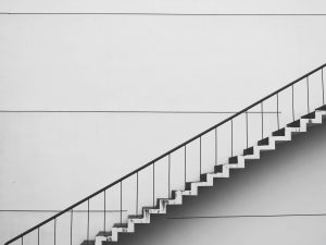 A staircase rising diagonally across a white wall