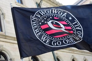 Figure 39.1. QAnon flag with a Q over the stars and stripes, that reads "Where we go one we go all"